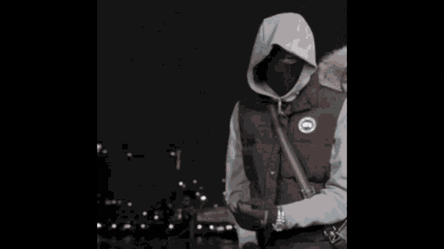 a man in a hoodie is standing in a dark room with a glitch effect