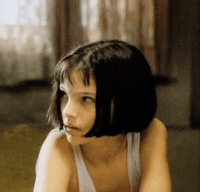 a young girl with short hair is wearing a tank top