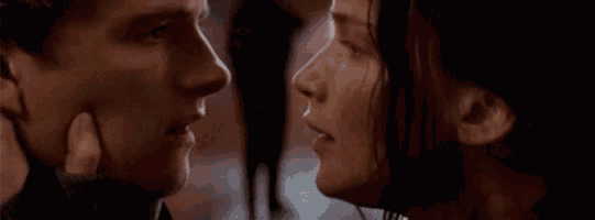 a man and a woman are touching each other 's faces and looking at each other .