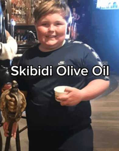 a boy in a nike shirt is holding a statue and a cup of skibidi olive oil