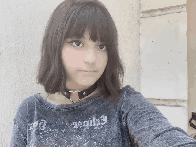 a girl wearing a choker and a t-shirt with the word devil on it