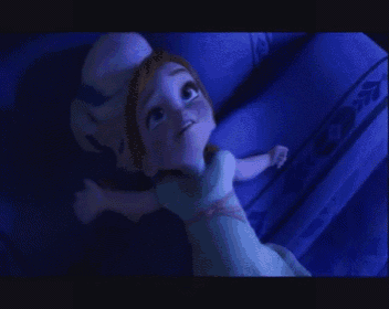 a cartoon girl is laying on a bed with a blue blanket