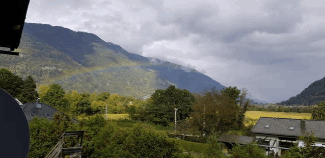 a view of a mountain with a rainbow in the distance