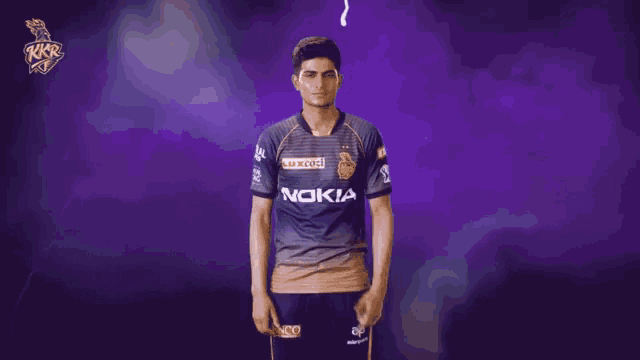 a man wearing a nokia shirt stands with his hands in his pockets