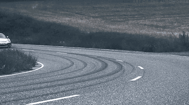 a black and white photo of a car on a road with the words art online automobile on the bottom