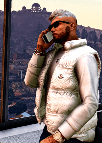 a man in a white moncler vest talks on a cell phone