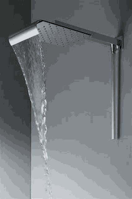 a shower head with water coming out of it is on a wall .