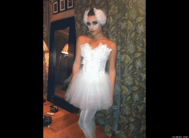 a woman in a white dress with a swan headband