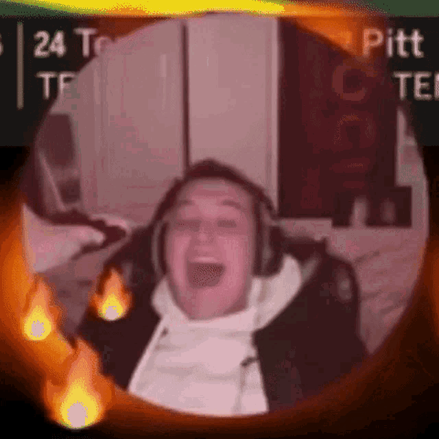 a man wearing headphones is making a funny face in a circle with flames .