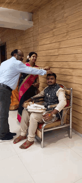 a man is sitting in a chair and a woman is standing behind him