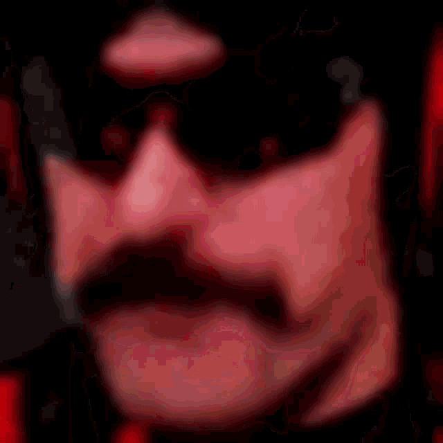 a blurry picture of a woman 's mouth with red lipstick on it .