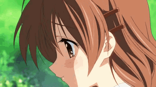 a close up of a girl 's face with red hair clips in her hair