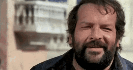 a man with a beard is smiling and looking at the camera .
