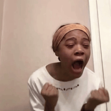 a woman is making a funny face with her mouth open and her hands in the air .
