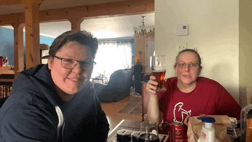 a man and a woman are sitting at a table with a can of diet coke