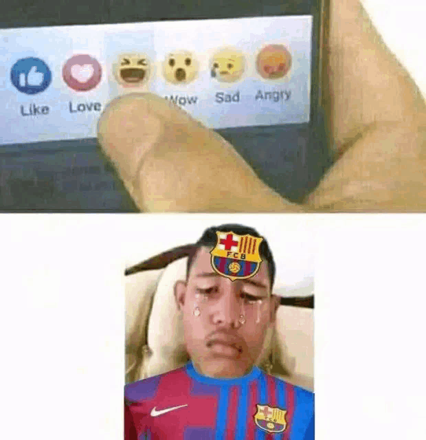 a person is holding a cell phone with a picture of a boy with a fcb logo on his forehead .