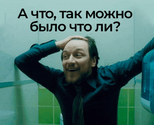 a man in a blue shirt holds his hand to his head in front of a sign that says a что так можно