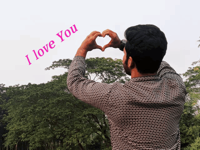 a man making a heart shape with his hands with the words i love you written in the background