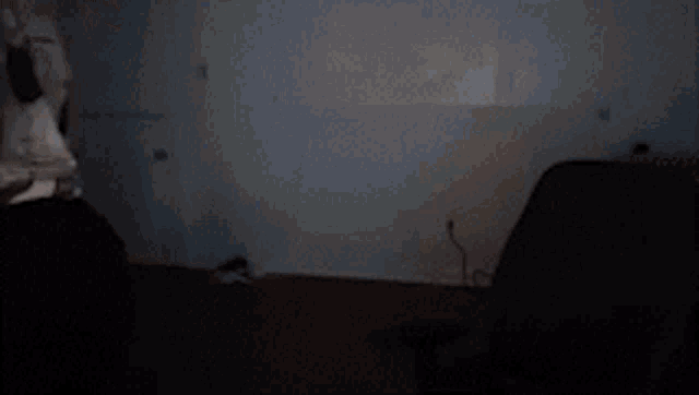 a man in a t-shirt is holding a light in a dark room