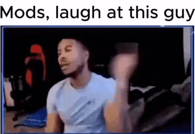 a man in a white shirt is laughing while sitting in front of a computer screen .