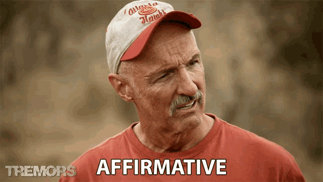 a man wearing a hat and a red shirt with the word affirmative on it