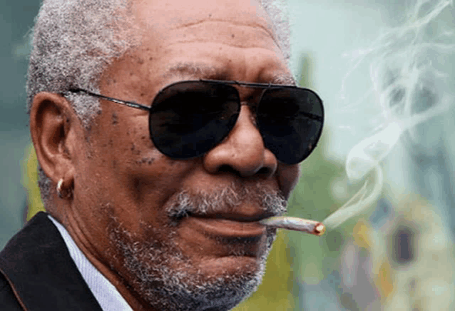 a man with a beard wearing sunglasses is smoking a cigarette