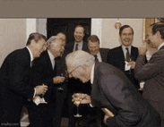 a group of men are laughing and drinking wine