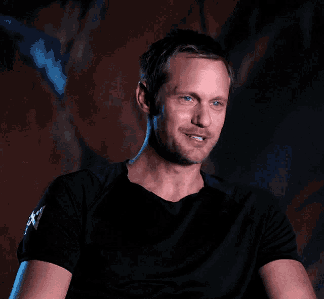 a man wearing a black shirt with the letter x on the sleeve