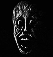 a black and white drawing of a scary face with a mouth open in the dark .