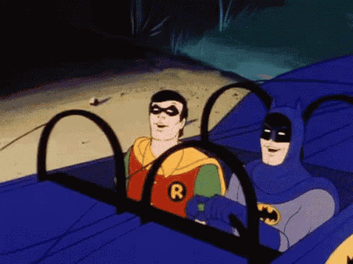 batman and robin are sitting in a car together .