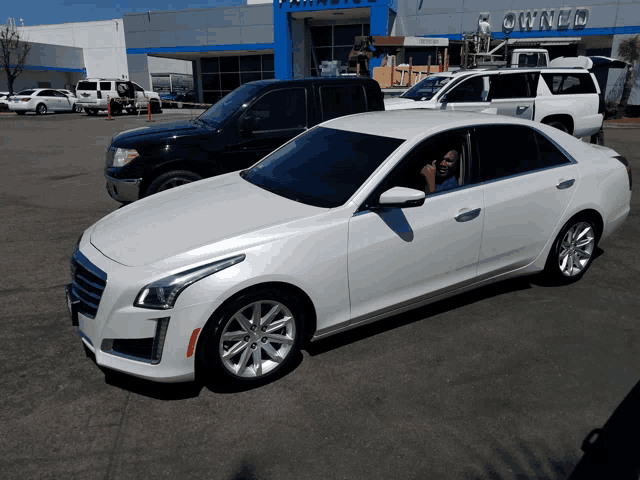 a white car is parked in front of a building with the word owned on it