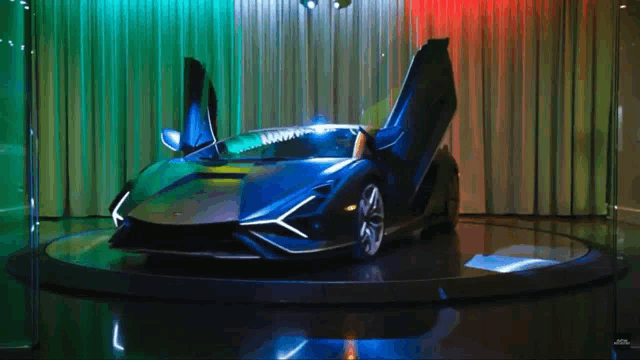 a black sports car with its doors open is on display in a showroom