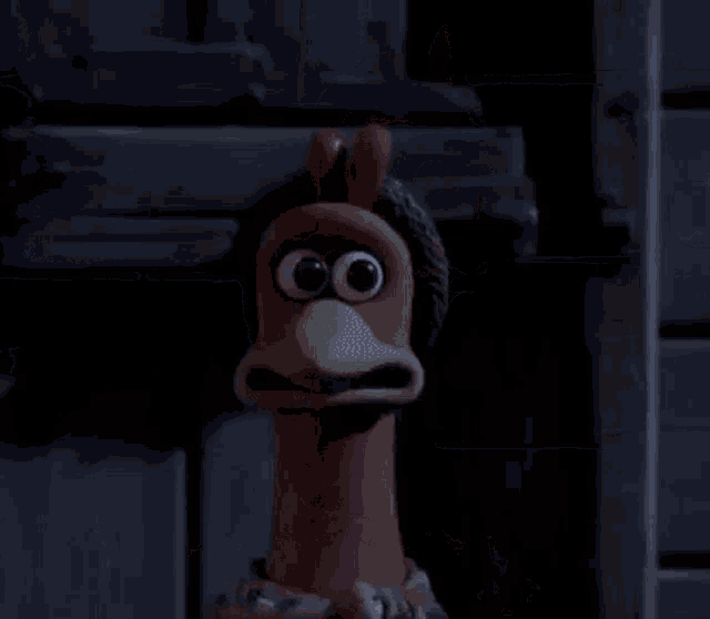 a cartoon chicken is tied up with a rope and has its arms outstretched in a dark room .