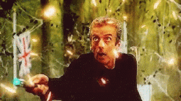 a man in a black shirt is holding a british flag in front of a broken glass wall .