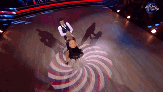a man and a woman are dancing on a stage with the words dancing brasil on the bottom right