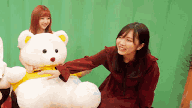 a woman petting a teddy bear with a yellow shirt on