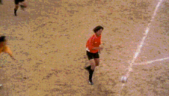 a group of soccer players are playing on a field and one of them is wearing a red shirt