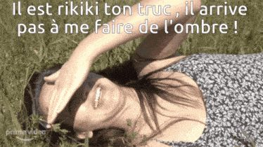 a woman is laying in the grass with her hand on her forehead and the words " il est rikiki ton truc " above her