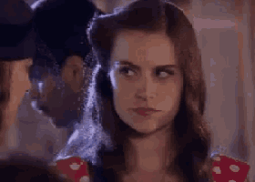 a woman in a red and white polka dot dress is looking at a man