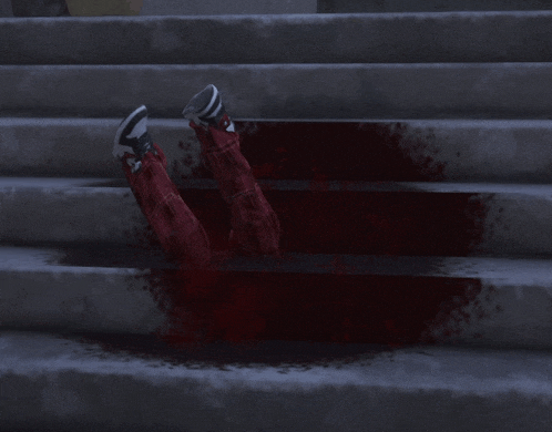 a person laying on a set of stairs with their feet in the blood