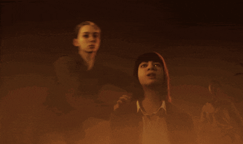 a man and a woman are standing in a dark room with a ghost behind them