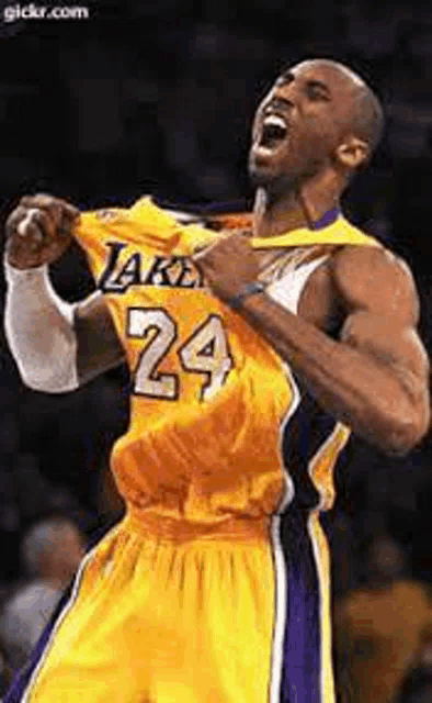 a basketball player wearing a yellow jersey with the number 24 on it is taking off his shirt .