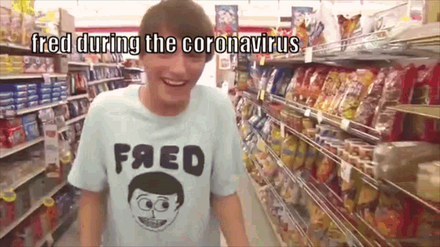 a man wearing a shirt that says fred is standing in a store