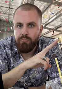 a man with a beard and a ring on his finger pointing