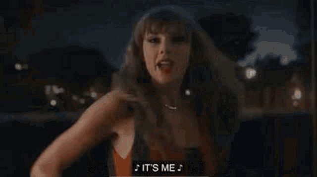 a woman is standing in front of a window at night with her hair blowing in the wind and saying `` it 's me '' .