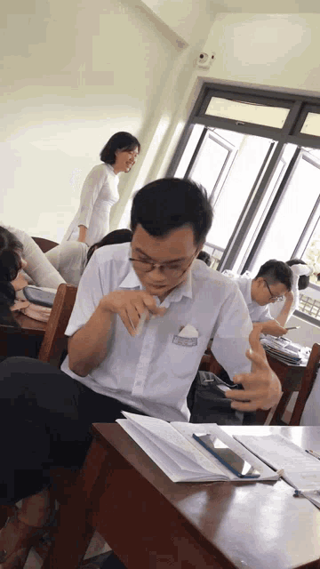 a man in a white shirt with a name tag that says ' nguyen ' on it sits at a desk