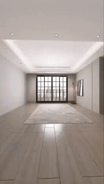 an empty living room with a rug on the floor and a large window