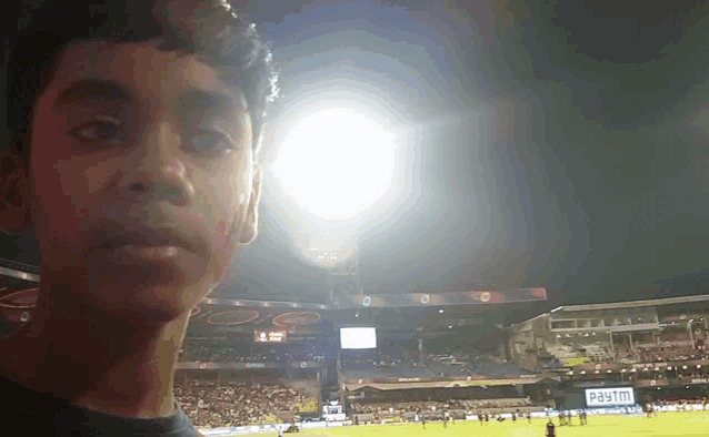 a boy taking a selfie in front of a paytm ad