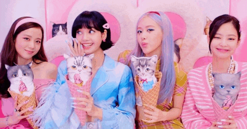 a group of women are holding ice cream cones with cats on them .