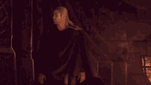 thor and loki are walking in front of a fire in a dark room